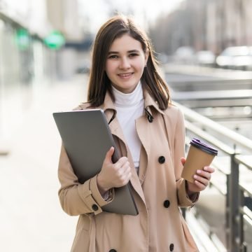 model in casual clothes working with her laptop outdoors