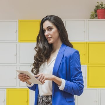 pretty-businesswoman-holding-tablet-office